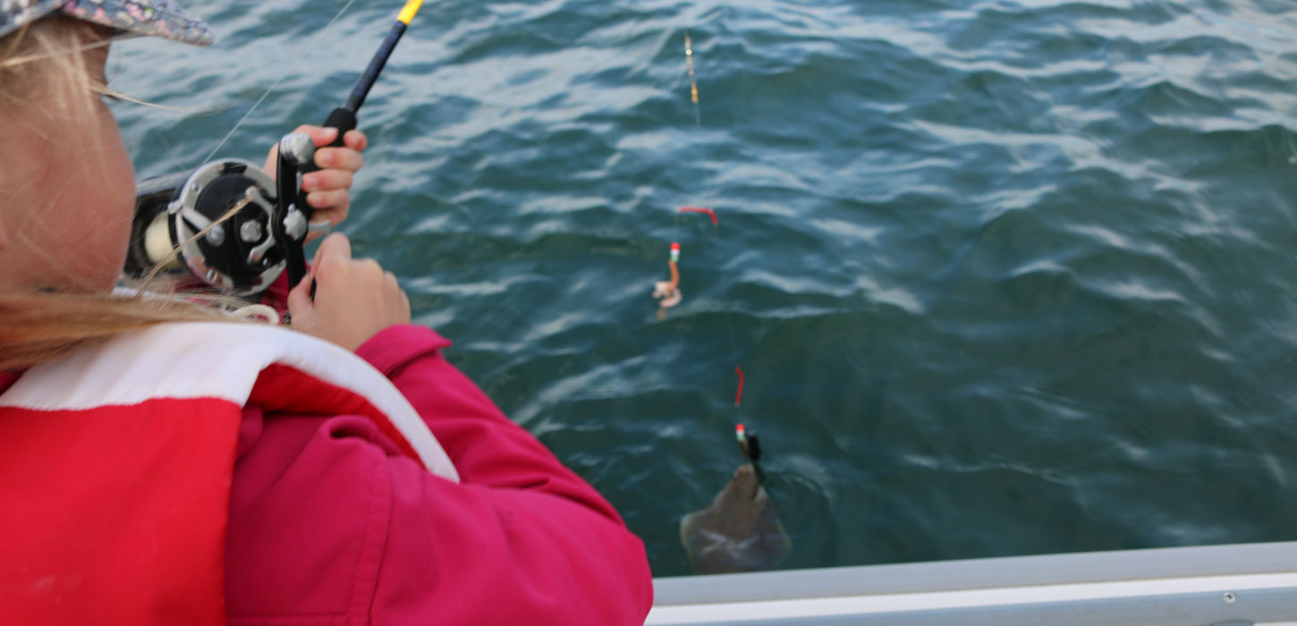 Ung pige fisker fra fiskekutter