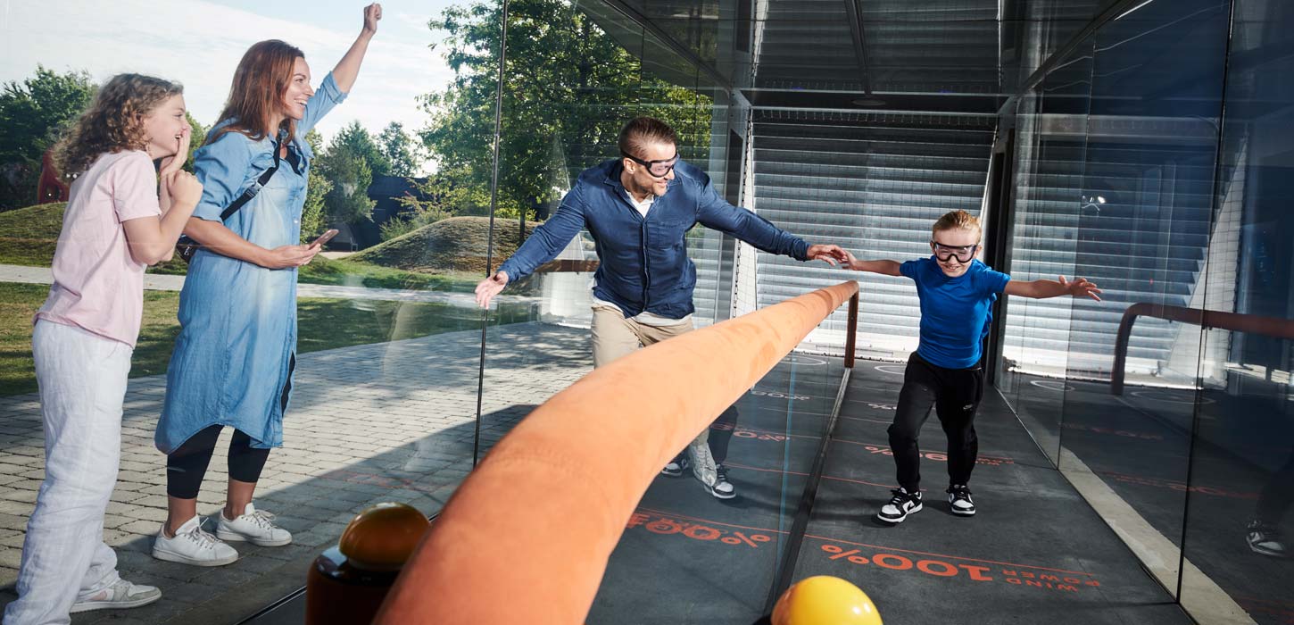 Far og søn dyster i Beat the Storm i Universe Science Park mens mor og datter hepper