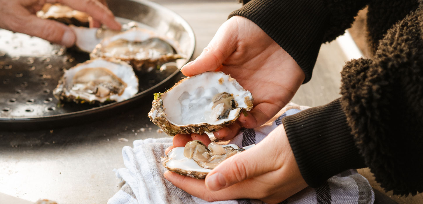 Hænder holder åben østers