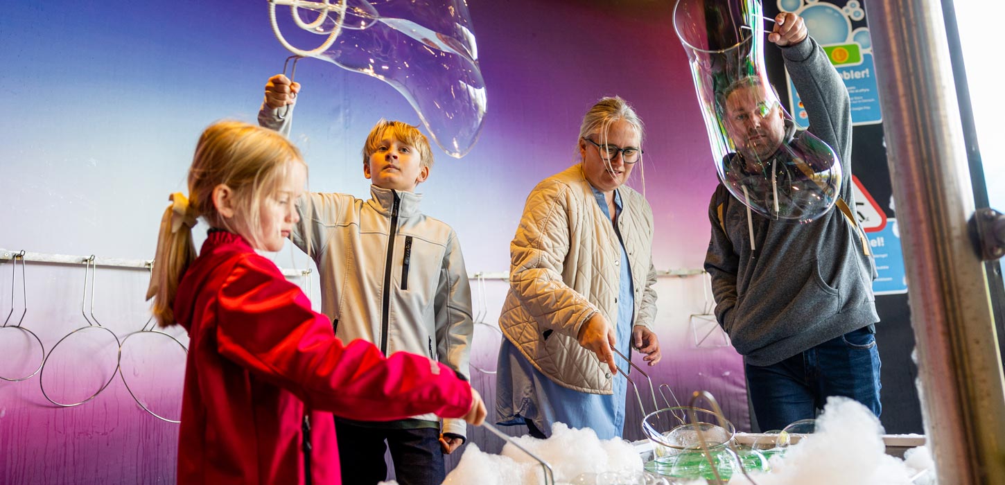 Familie med dreng og pige leger med sæbebobler i Bubble Lab i Universe Science Park