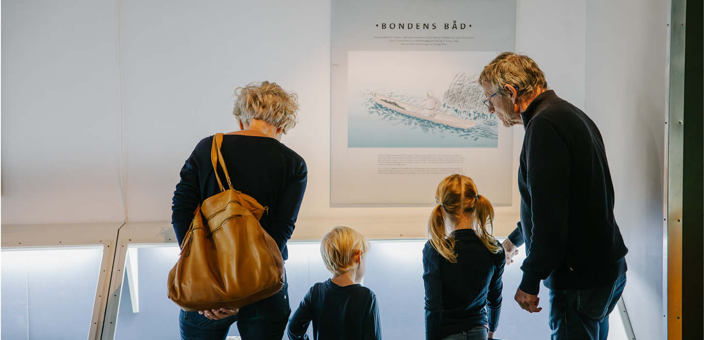 bedsteforældre og børnebørn kigger på en udstilling